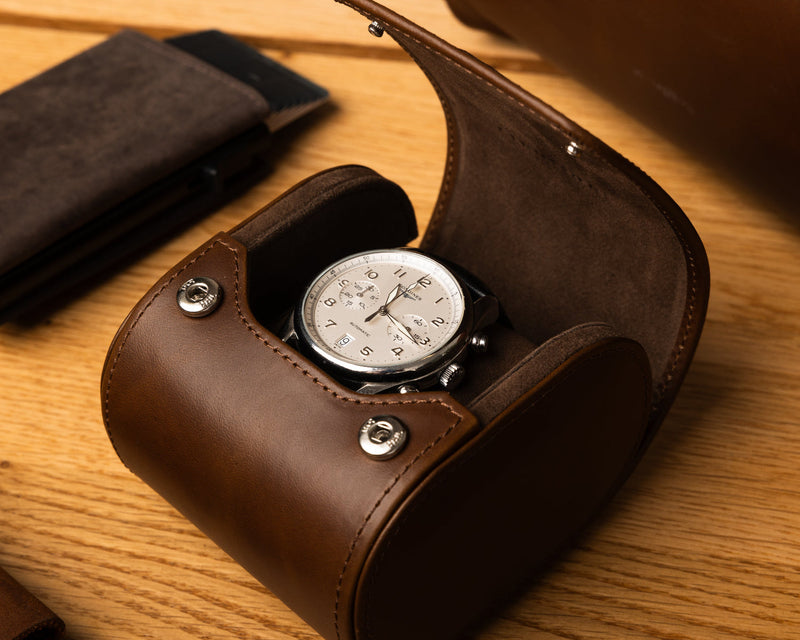 Dark brown watch box from Gentlemen's with a luxury watch